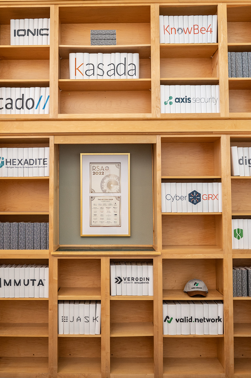 Library shelves with security company logos printed on the book spines