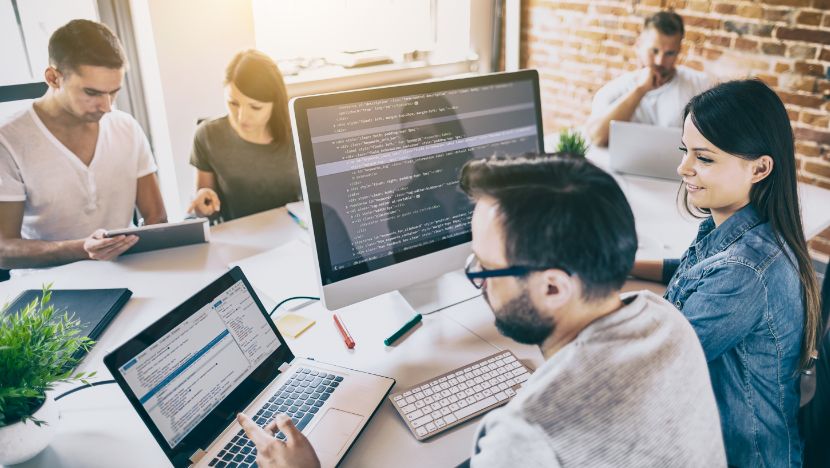 Team working together on devices at a conference table